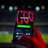 Android smartphone displaying SportyBet Nigeria app download page with a clear download button